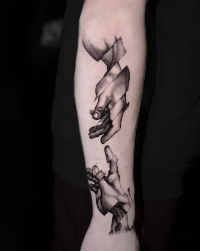 Tatuaj black and grey cu mâini abstracte pe antebraț