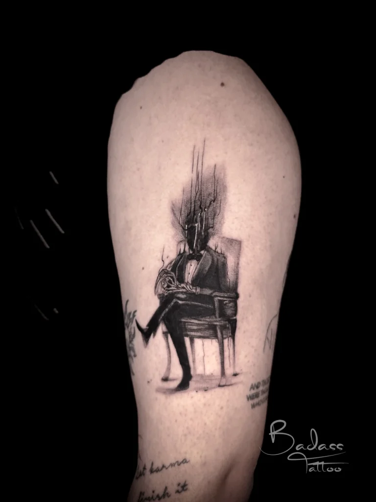Tatuaj realizat de Cătălina — Personaj în costum cu elemente abstracte pe braț