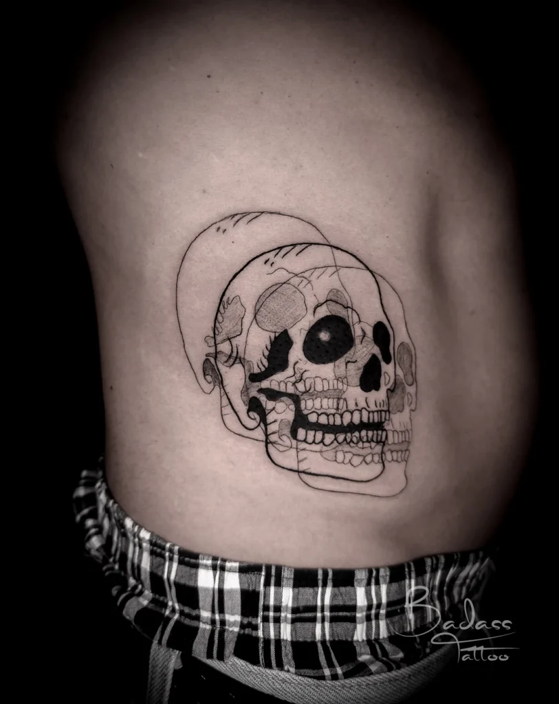 Tatuaj realizat de Cătălina — Cranii suprapuse în linii negre