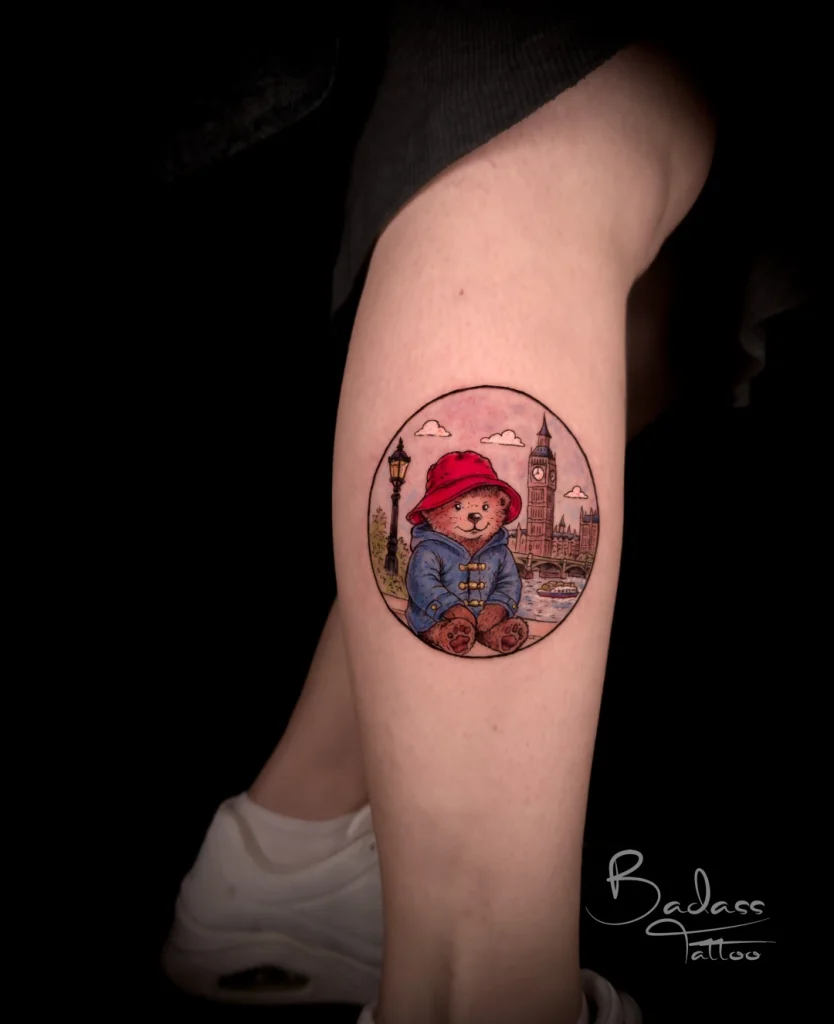 Tatuaj realizat de Cătălina — Ursuleț Paddington și peisaj londonez color pe gambă