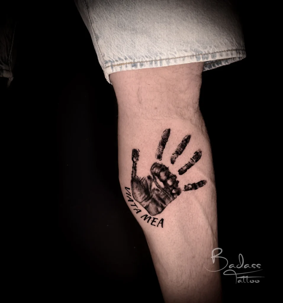 Tatuaj realizat de Cătălina — Amprentă de palmă și inscripție pe gambă